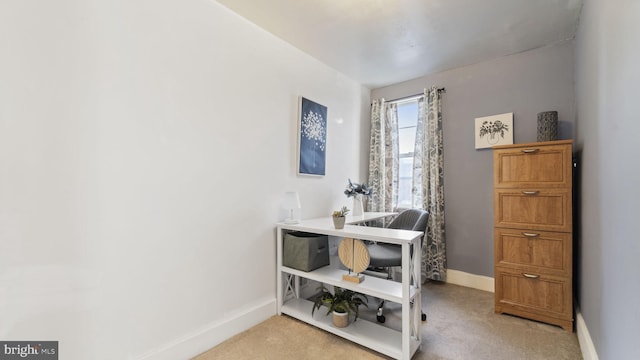 office area featuring baseboards and light colored carpet