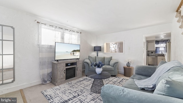 living area with a textured wall, a fireplace, and baseboards