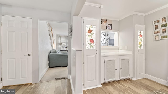 interior space featuring ornamental molding, wood finished floors, visible vents, and baseboards