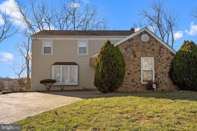 exterior space featuring stone siding, a lawn, a chimney, and stucco siding