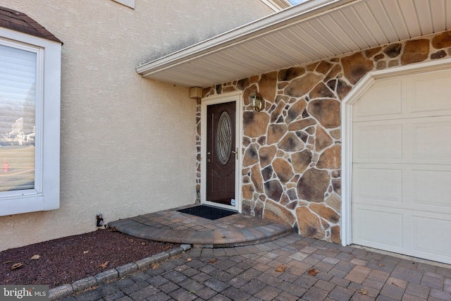 entrance to property with stone siding and stucco siding