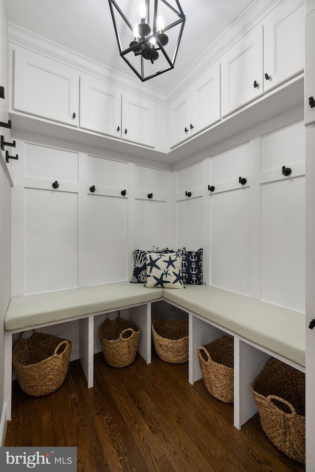 mudroom with a notable chandelier and dark wood-type flooring