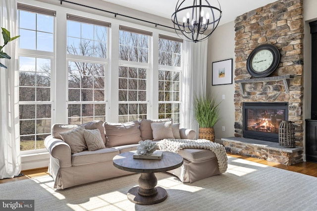 living area featuring a fireplace, wood finished floors, and a chandelier