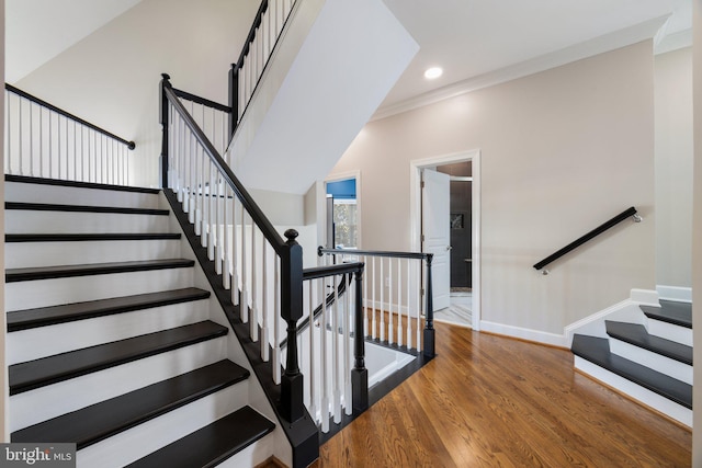 staircase with recessed lighting, baseboards, wood finished floors, and ornamental molding