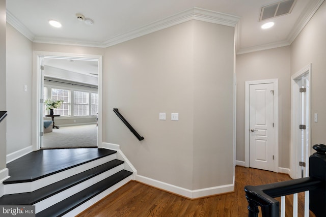 stairway with visible vents, ornamental molding, baseboards, and wood finished floors