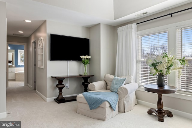 living area featuring visible vents, carpet, and baseboards