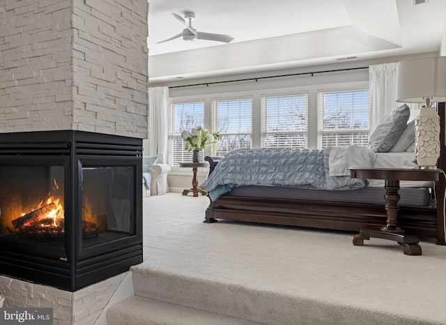 carpeted bedroom with multiple windows, a fireplace, and visible vents