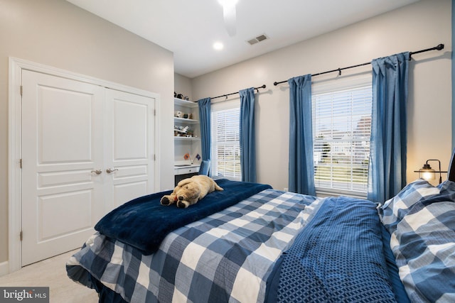 bedroom featuring a closet, visible vents, and light colored carpet