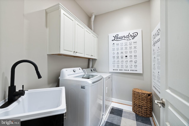 washroom featuring washing machine and clothes dryer, cabinet space, baseboards, and a sink