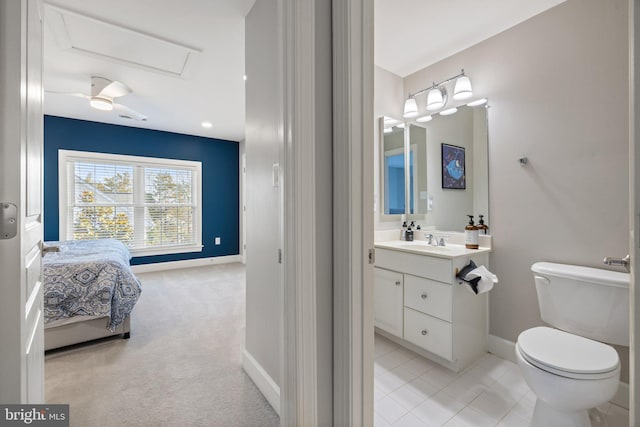 ensuite bathroom with vanity, toilet, and baseboards