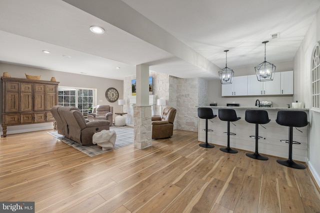 bar featuring recessed lighting, light wood-type flooring, visible vents, and hanging light fixtures