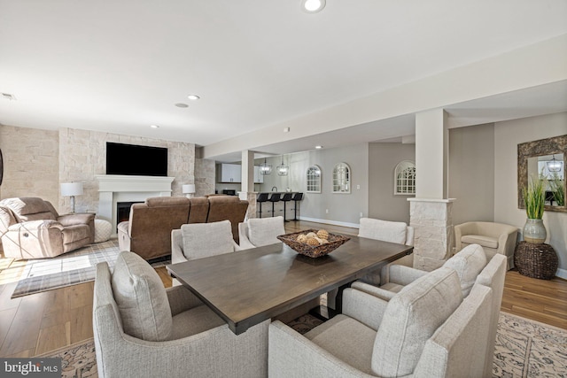 dining area featuring recessed lighting, a fireplace, and wood finished floors