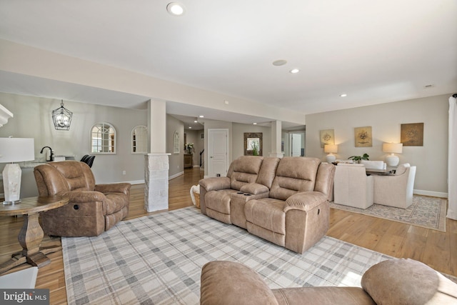 living room featuring recessed lighting, light wood-style floors, baseboards, and a chandelier