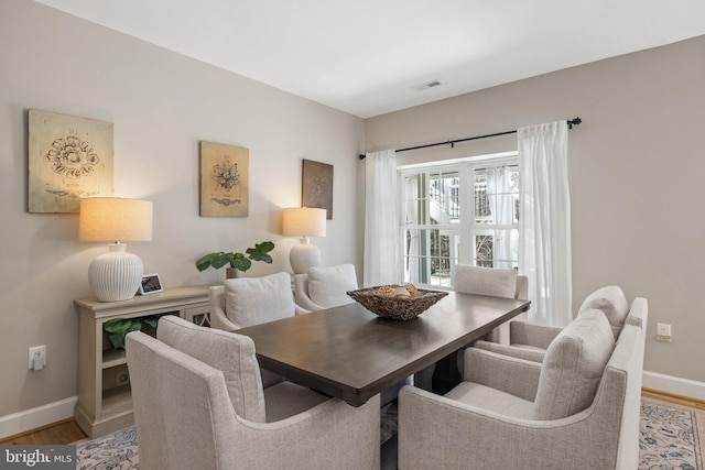 dining area featuring light wood-type flooring and baseboards