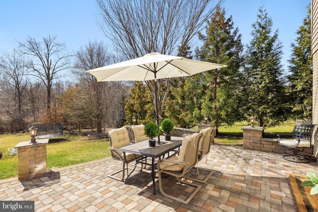 view of patio featuring a trampoline and outdoor dining space