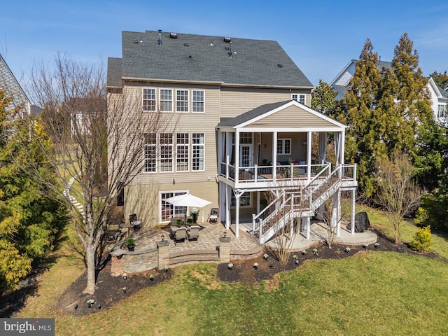 rear view of property featuring a yard, a patio, roof with shingles, and stairs