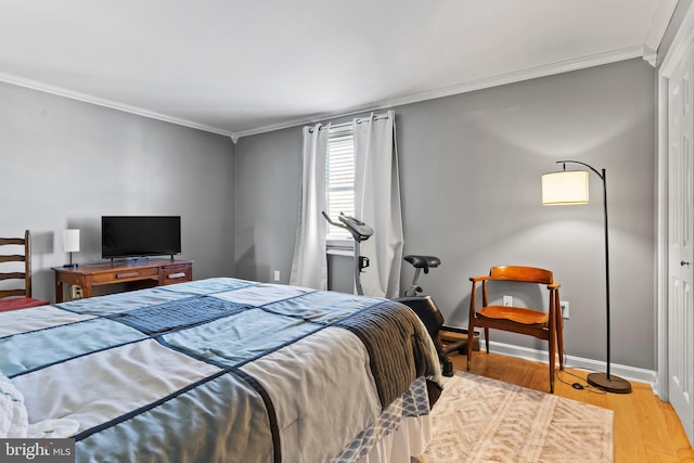 bedroom with baseboards, wood finished floors, and crown molding