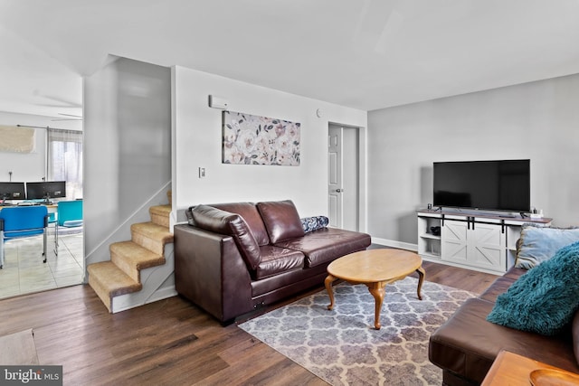 living area with stairway, baseboards, and wood finished floors