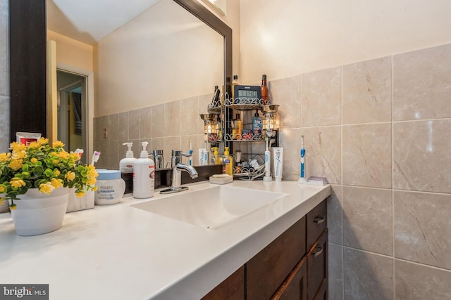 bathroom featuring vanity and tile walls