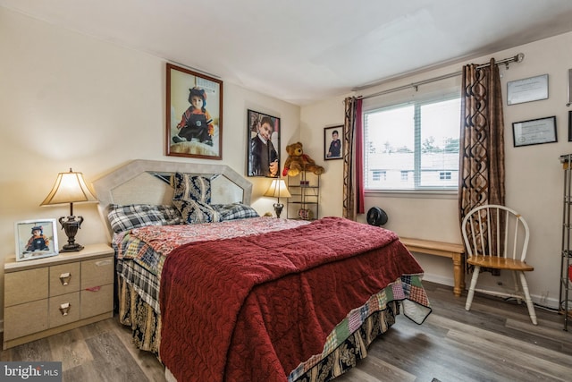 bedroom with baseboards and wood finished floors