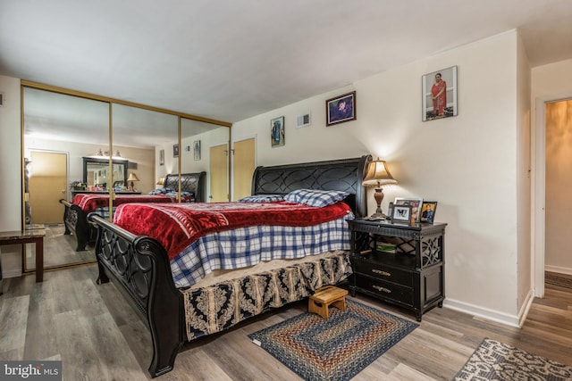 bedroom featuring a closet, wood finished floors, and baseboards