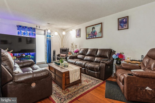 living room with a textured ceiling and wood finished floors