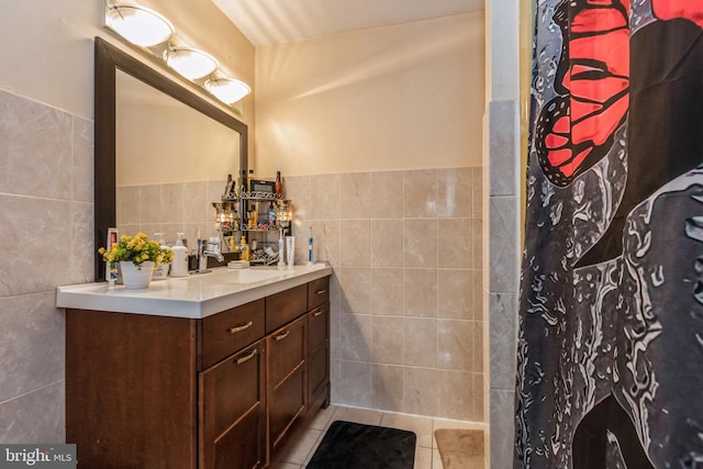 bathroom featuring a wainscoted wall, tile walls, a shower with shower curtain, vanity, and tile patterned flooring