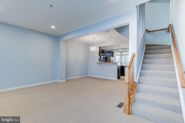 interior space with baseboards, stairs, visible vents, and light colored carpet