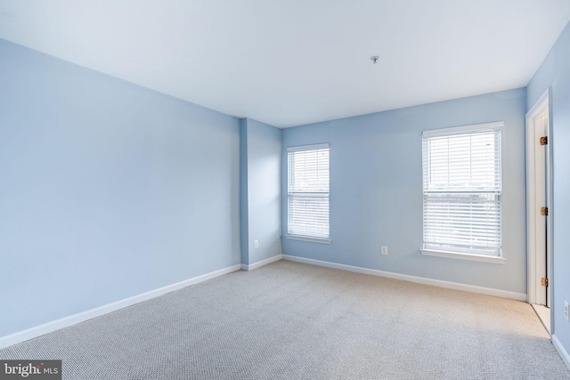 carpeted empty room with baseboards