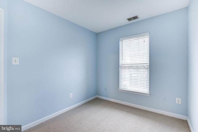 carpeted empty room with visible vents and baseboards