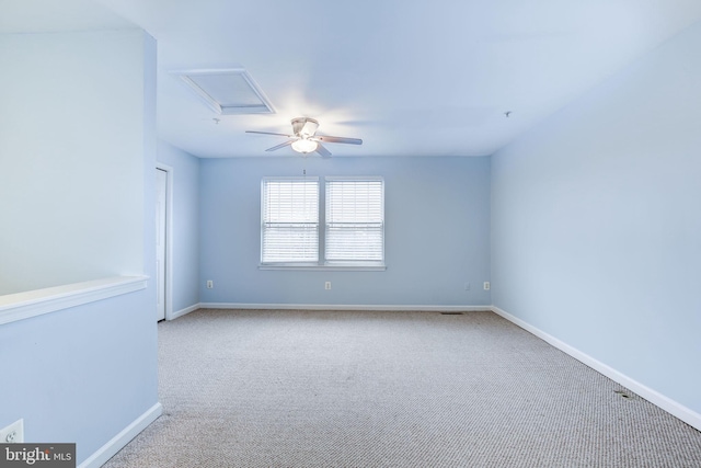 spare room featuring ceiling fan, visible vents, baseboards, carpet, and attic access