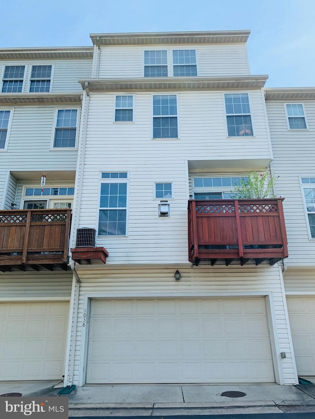 view of front of house featuring an attached garage and a balcony