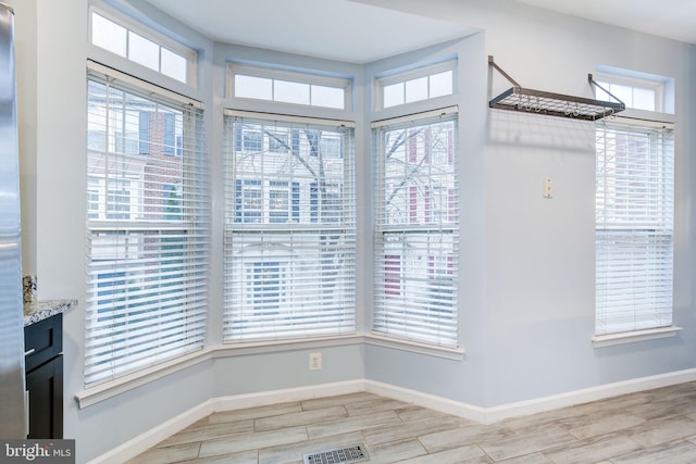 interior space featuring wood finish floors, visible vents, and baseboards