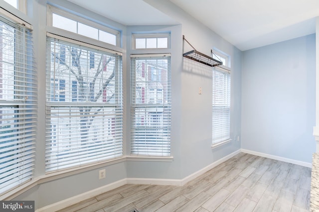 unfurnished dining area with wood finish floors and baseboards