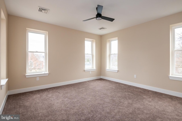 empty room featuring carpet, visible vents, ceiling fan, and baseboards