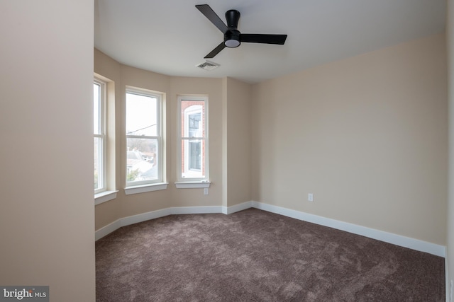 spare room featuring carpet floors, baseboards, visible vents, and a ceiling fan