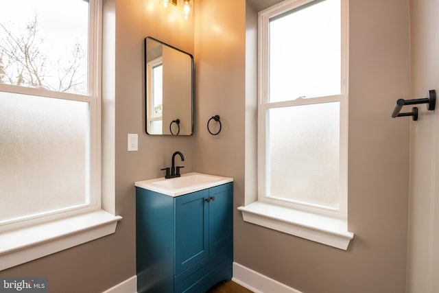 bathroom with plenty of natural light, vanity, and baseboards