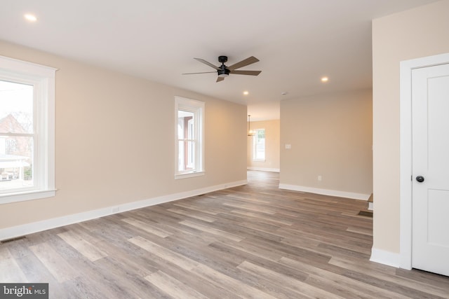 spare room with ceiling fan, recessed lighting, wood finished floors, visible vents, and baseboards