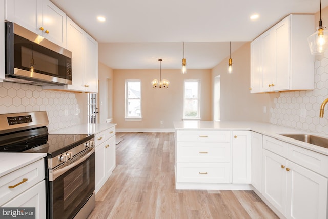 kitchen with white cabinetry, light wood-style flooring, appliances with stainless steel finishes, and a sink