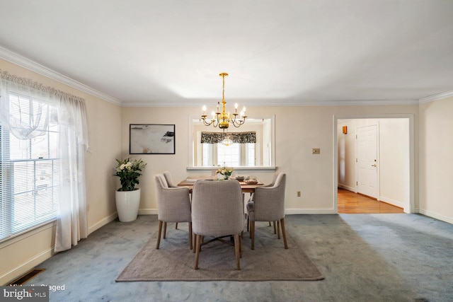 dining room with ornamental molding, carpet flooring, visible vents, and a chandelier