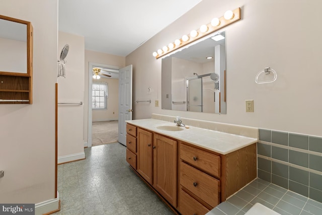 bathroom with tile patterned floors, a stall shower, vanity, and ceiling fan