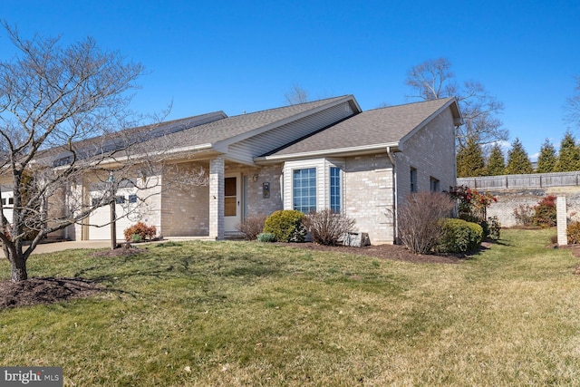 single story home featuring a front lawn, an attached garage, fence, and brick siding