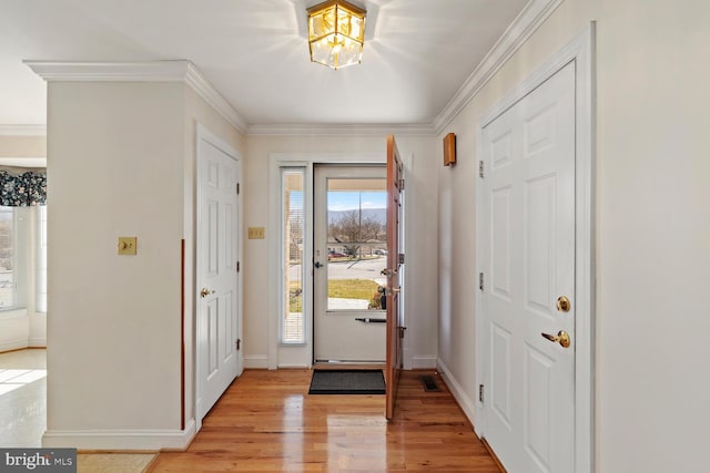 entrance foyer featuring light wood finished floors, visible vents, crown molding, and baseboards