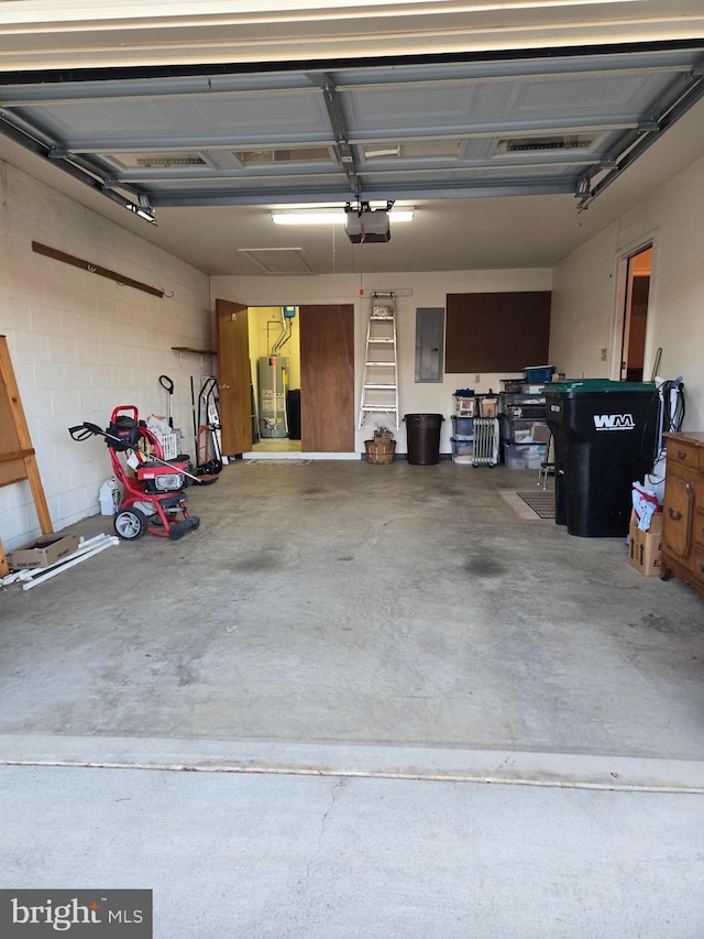 garage with electric panel, gas water heater, a garage door opener, and concrete block wall