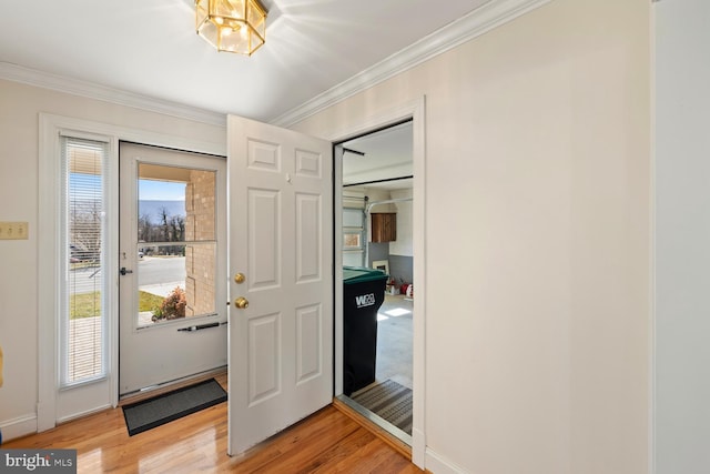 foyer featuring light wood-style floors, baseboards, and ornamental molding