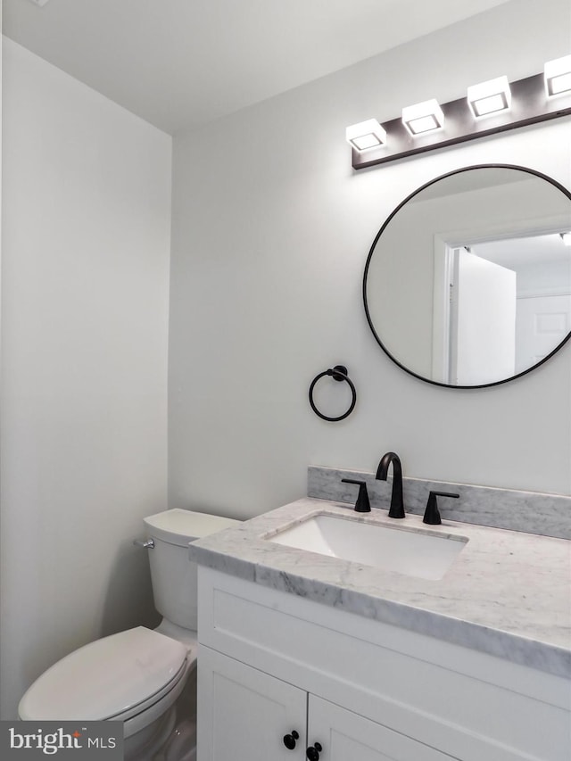 half bathroom featuring toilet and vanity