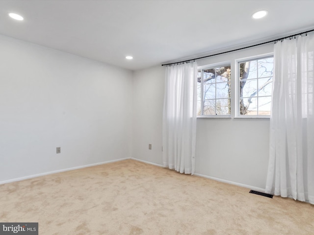 empty room featuring visible vents, recessed lighting, and carpet floors