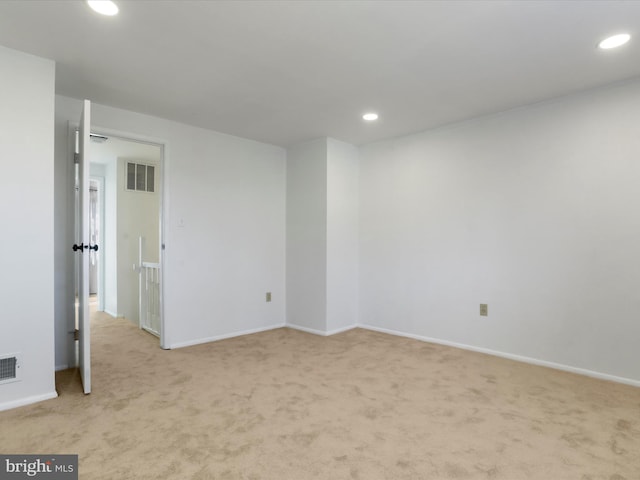 empty room with light colored carpet, recessed lighting, visible vents, and baseboards