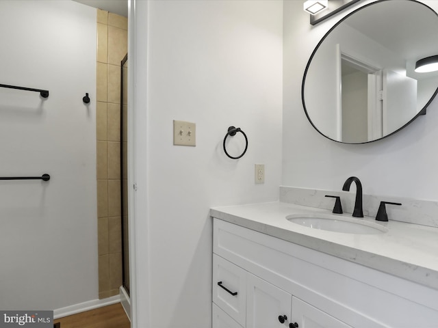 full bathroom featuring vanity, baseboards, and a tile shower