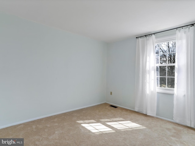 unfurnished room with baseboards, visible vents, and carpet floors